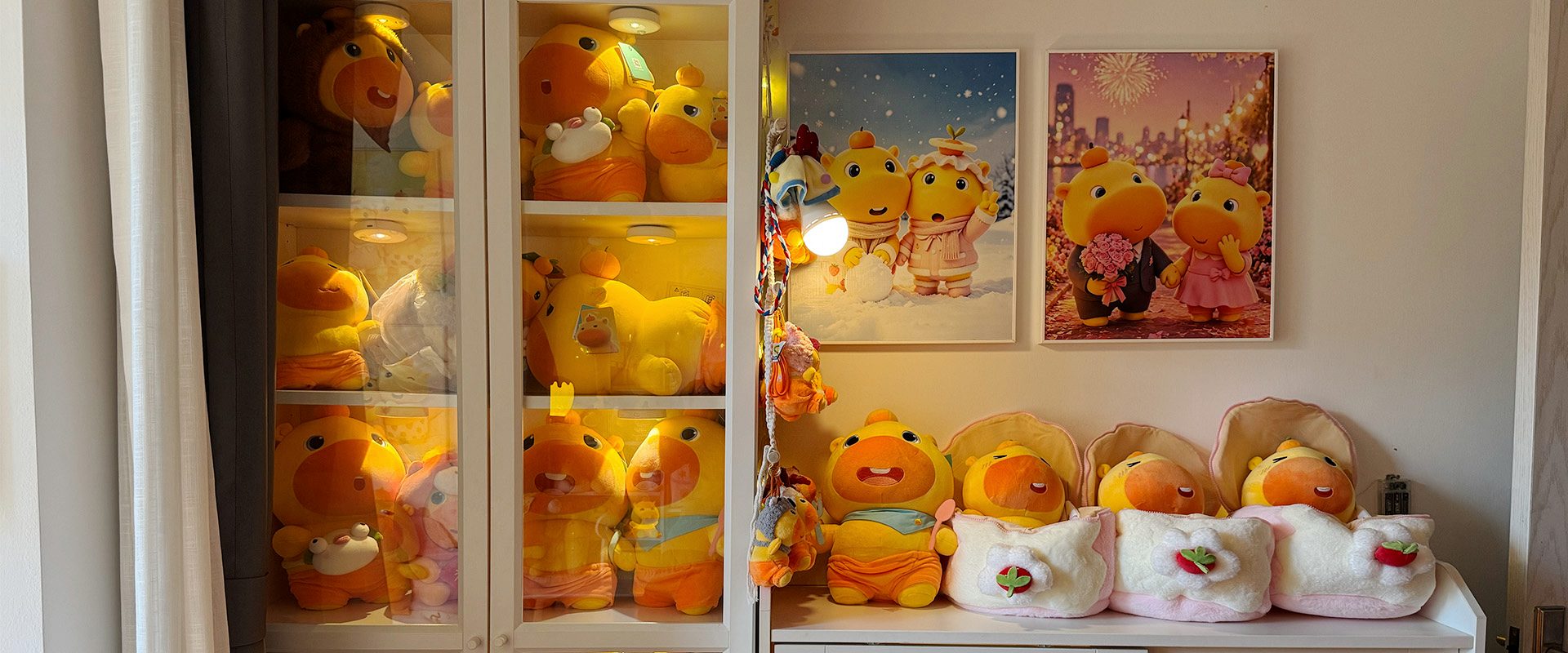 Lulu plush toys displayed in lit cabinets beneath framed winter and wedding scenes