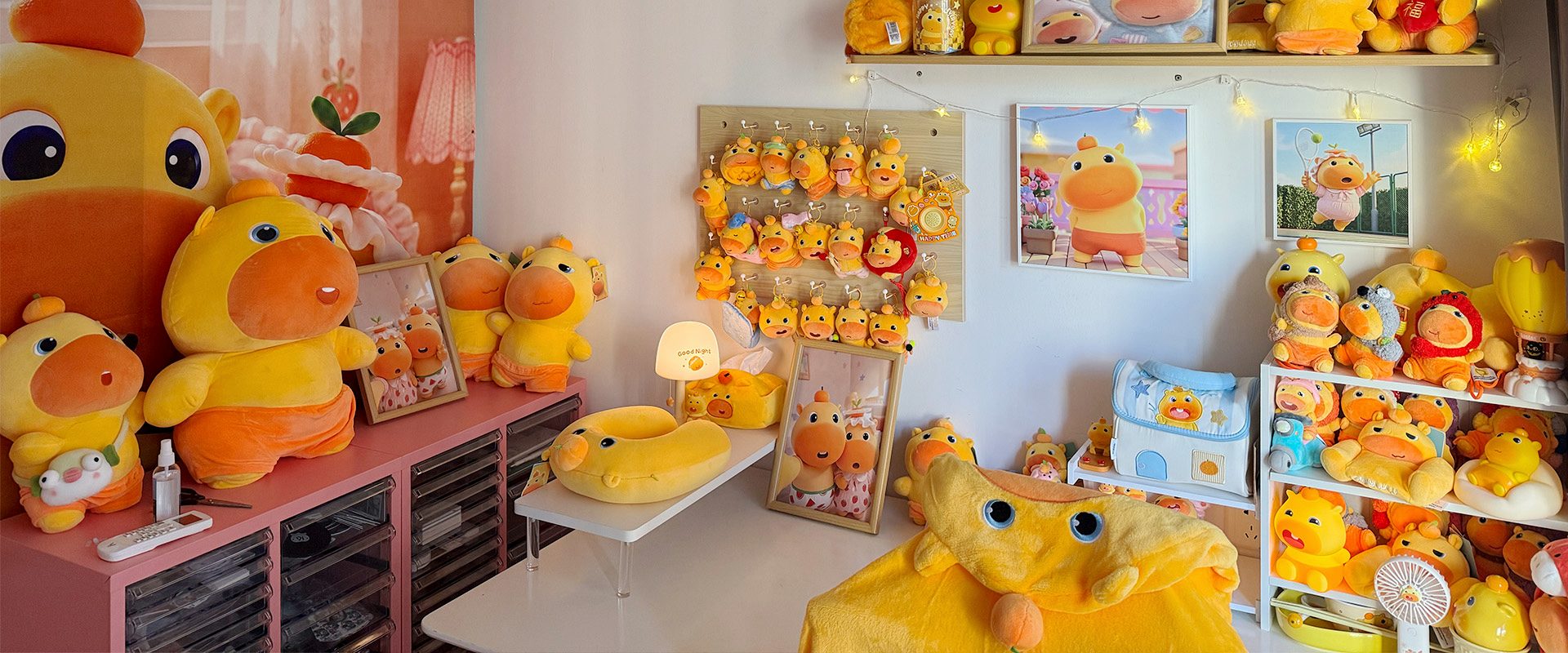 A colorful CapyLulumi studio corner with large plush figures, framed art, and collectibles